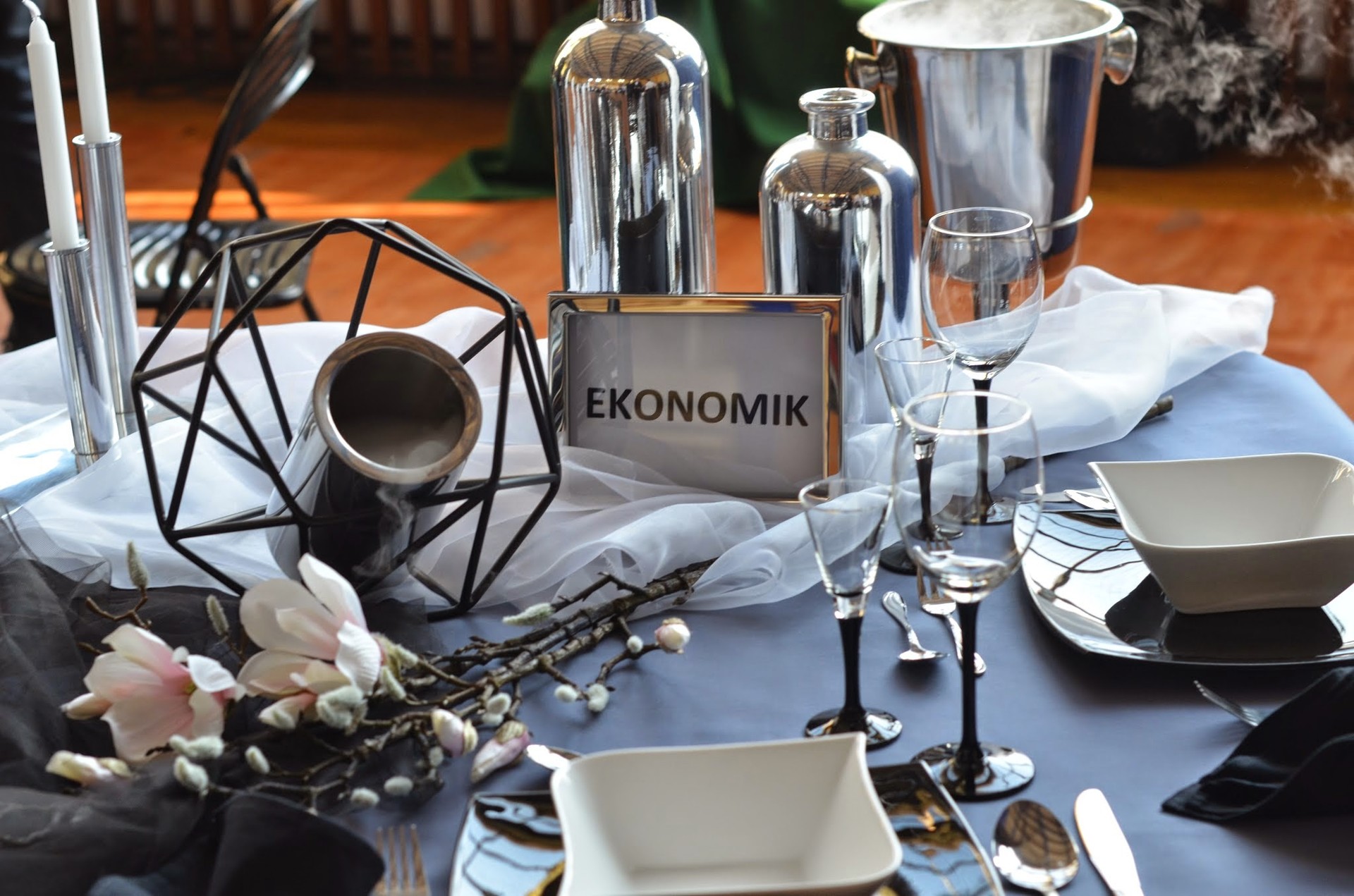 Stół z talerzami sztućcami oraz tabliczką Ekonomik